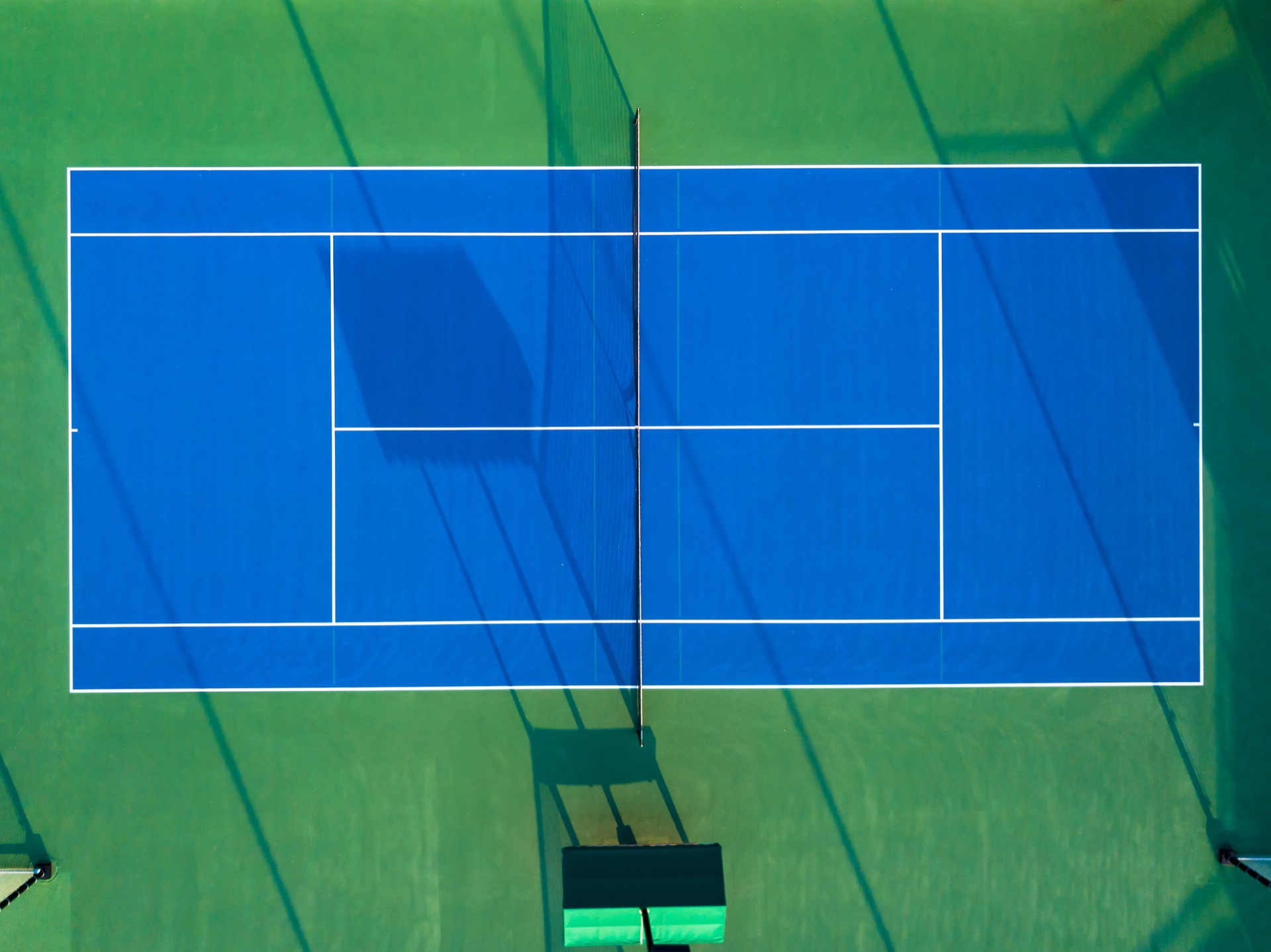 An overhead view of a blue and green tennis court.
