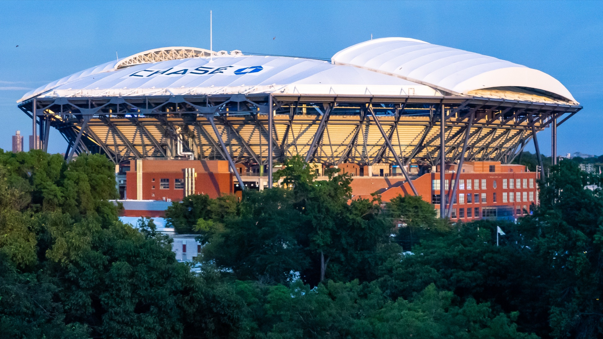 The exterior of Arthur Ashe Stadium in New York in evening light.