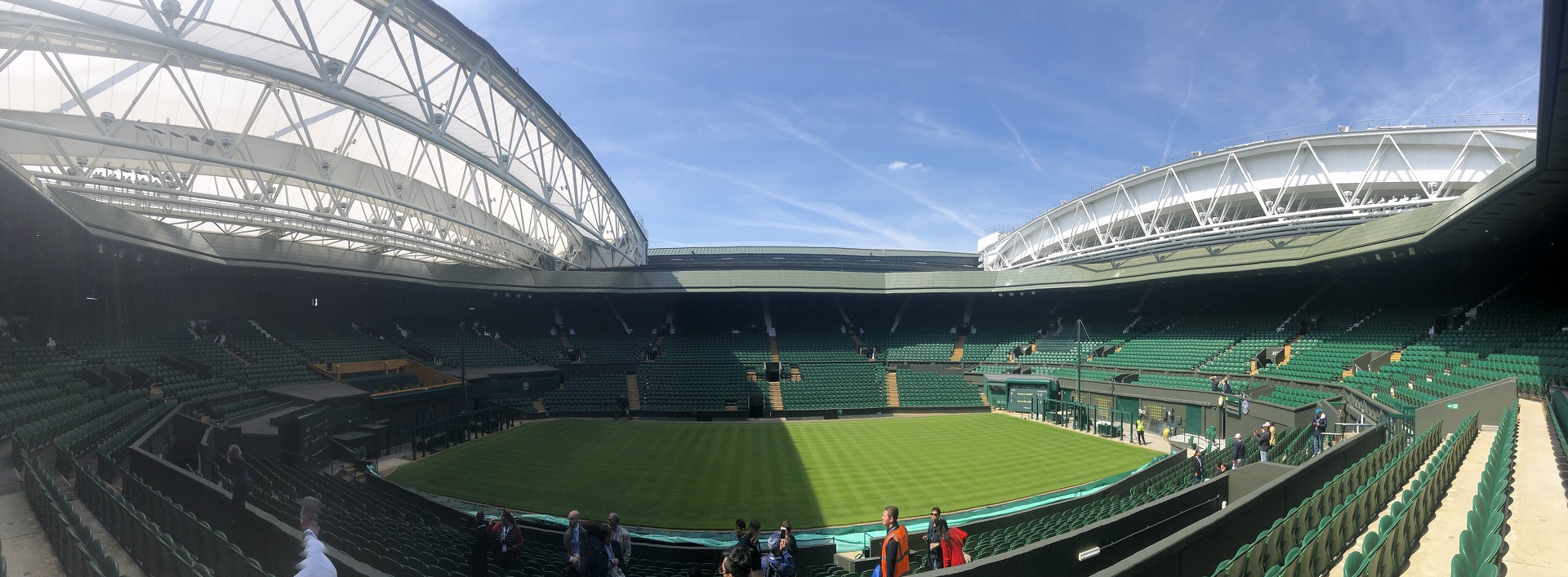The grass and green stands of Wimbledon Centre Court beneath its open roof.